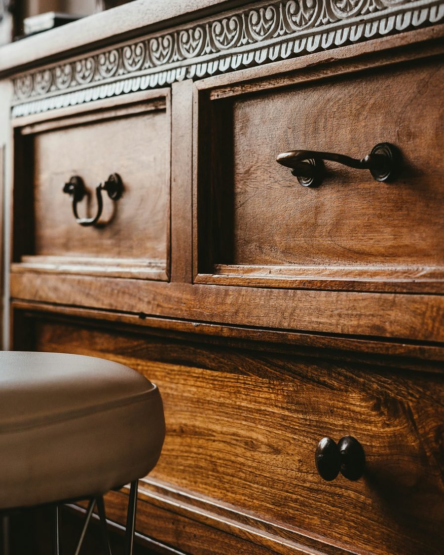Close-up of hand-finished drawer hardware on a restored solid wood dresser